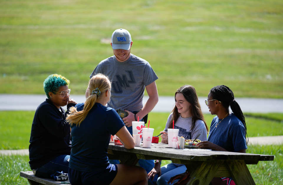 Students having lunch at a picnic table.